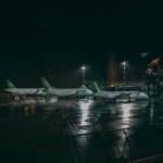 three white and green plane on the airport photography during nighttime