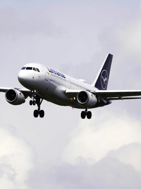 a large jetliner flying through a cloudy sky