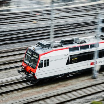 a white and red train traveling down train tracks