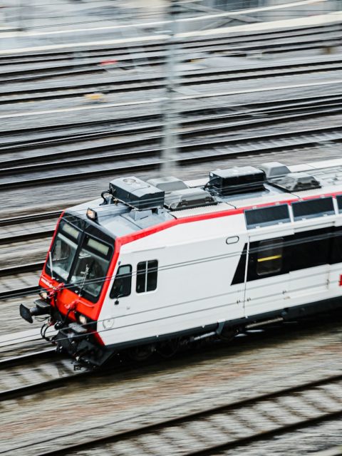 a white and red train traveling down train tracks