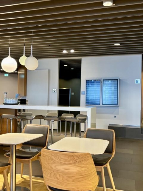 Un espace avec table et chaises ainsi que les prochains départ du Lufthansa Business Lounge A26 (Schengen) à Frankfurt