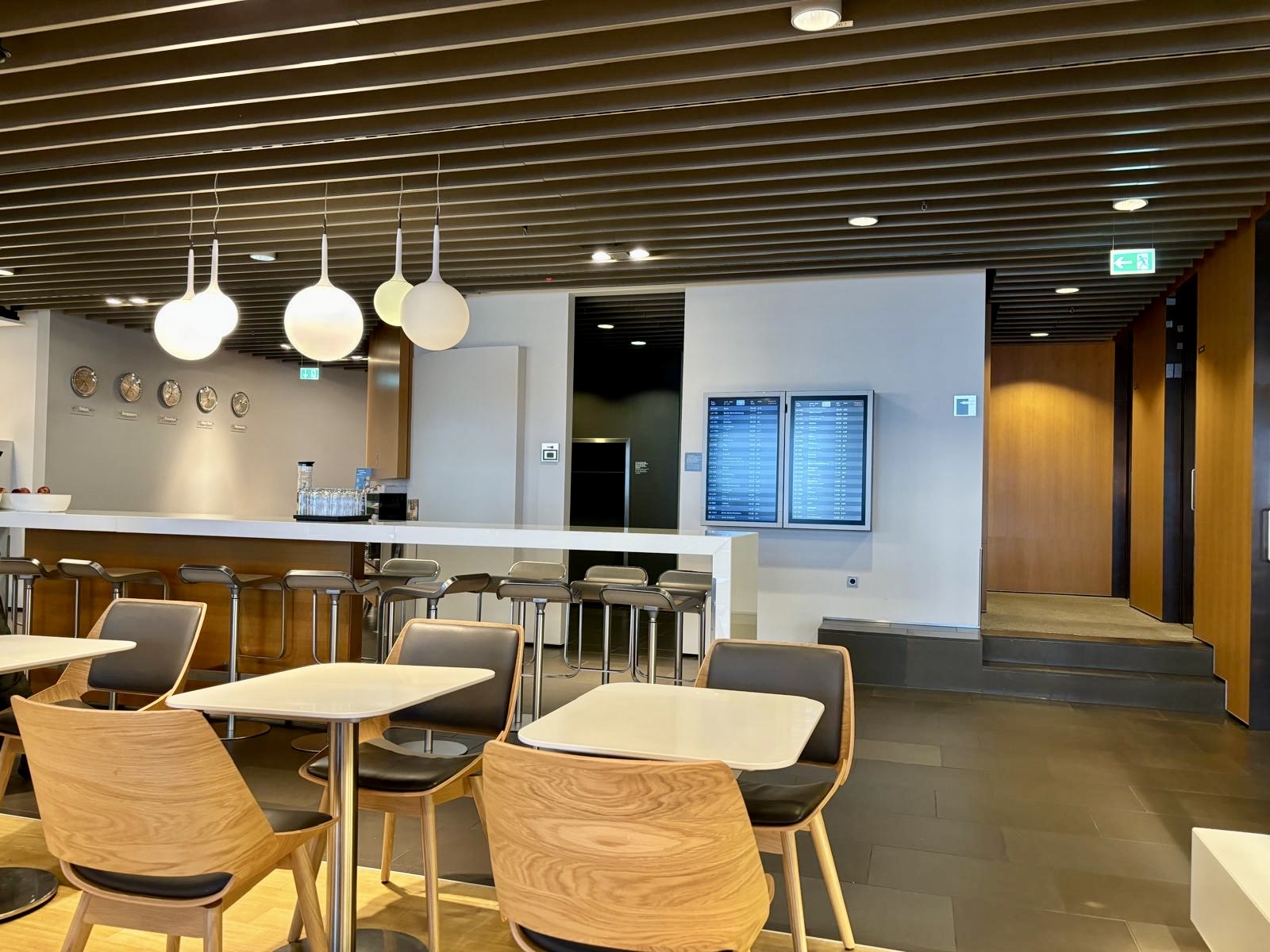 Un espace avec table et chaises ainsi que les prochains départ du Lufthansa Business Lounge A26 (Schengen) à Frankfurt