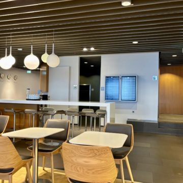 Un espace avec table et chaises ainsi que les prochains départ du Lufthansa Business Lounge A26 (Schengen) à Frankfurt