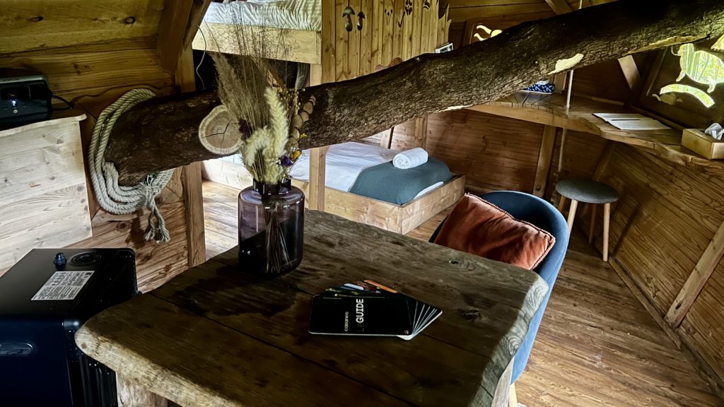 L'intérieur d'une cabane avec une table et un lit en arrière-plan