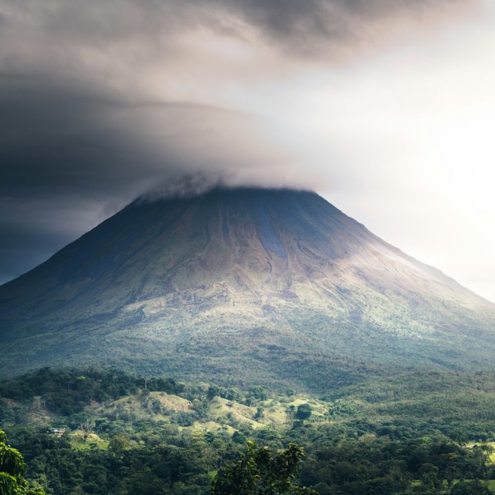 a very tall mountain with a very cloudy sky above it