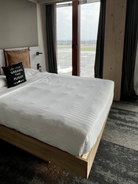 Un lit avec une vue sur des avions en arrière-plan