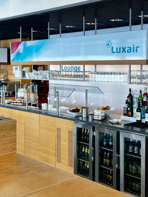 Un salon d'aéroport Luxair avec un buffet