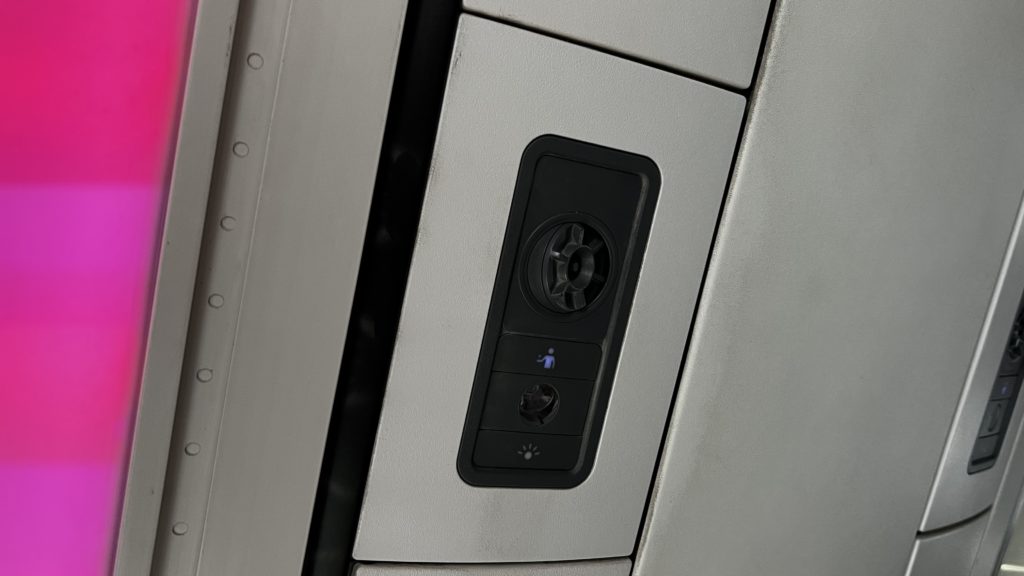 Un PSU dans un avion avec un bouton d'appel pour le service, une climatisation et une lampe
