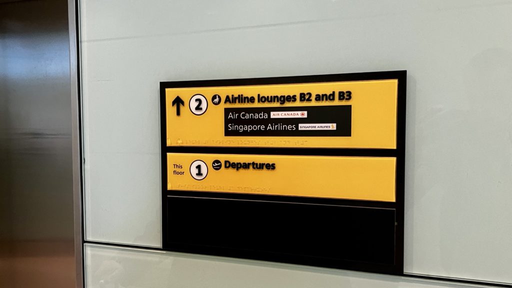 Un panneau dans un aéroport indiquant des directions pour accéder à des salons d