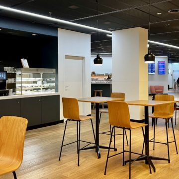 Un salon d'aéroport SWISS avec en arrière-plan une enseigne Breitling
