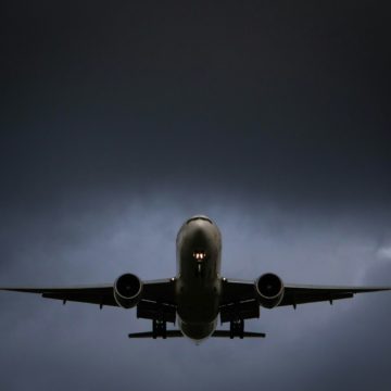 A large jetliner flying through a cloudy sky