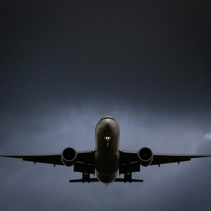 A large jetliner flying through a cloudy sky