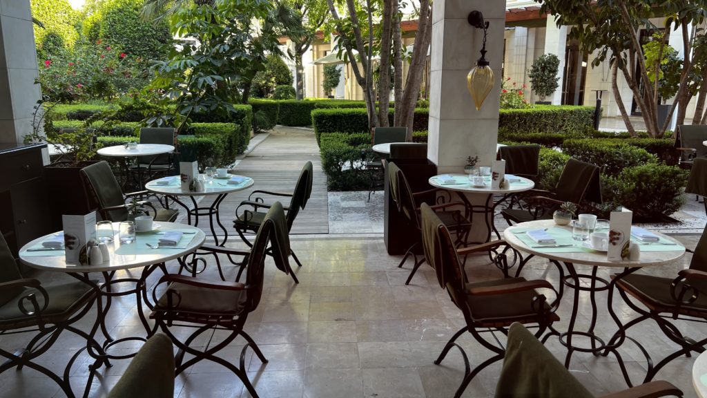 Une terrasse avec des tables dressées pour le petit-déjeuner et des couvertures sur les chaises