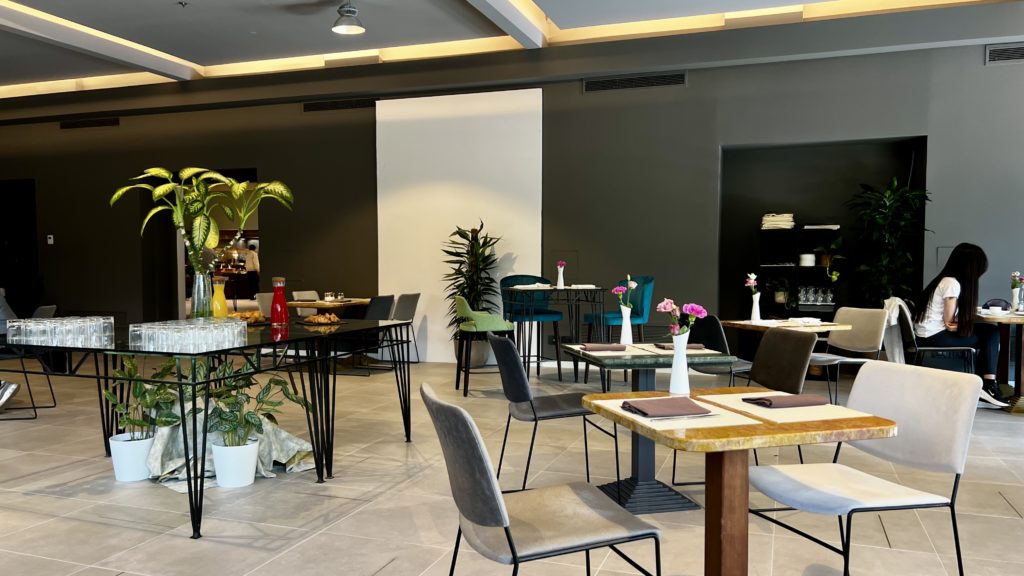 Une salle de petit-déjeuner avec des tables, des plantes