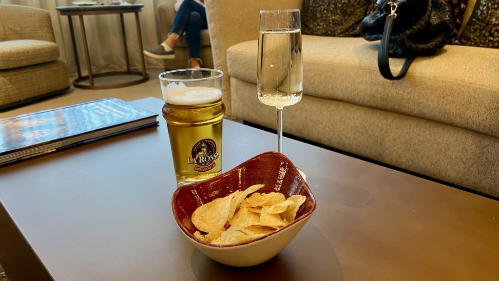 Un bol de chips avec une bière et un verre de prosseco