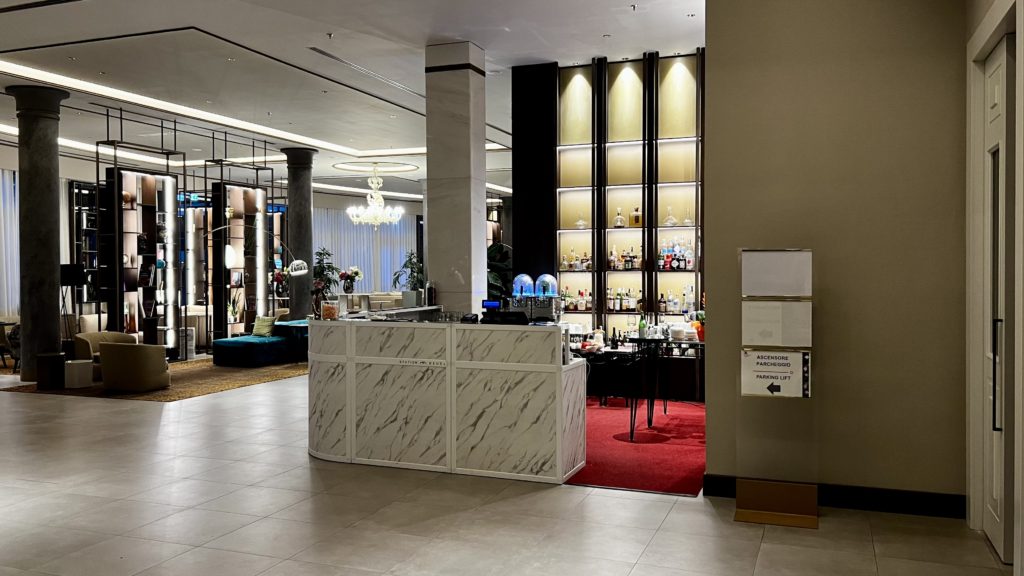 Un bar dans un hall d'hôtel avec en arrière-plan des fauteuils